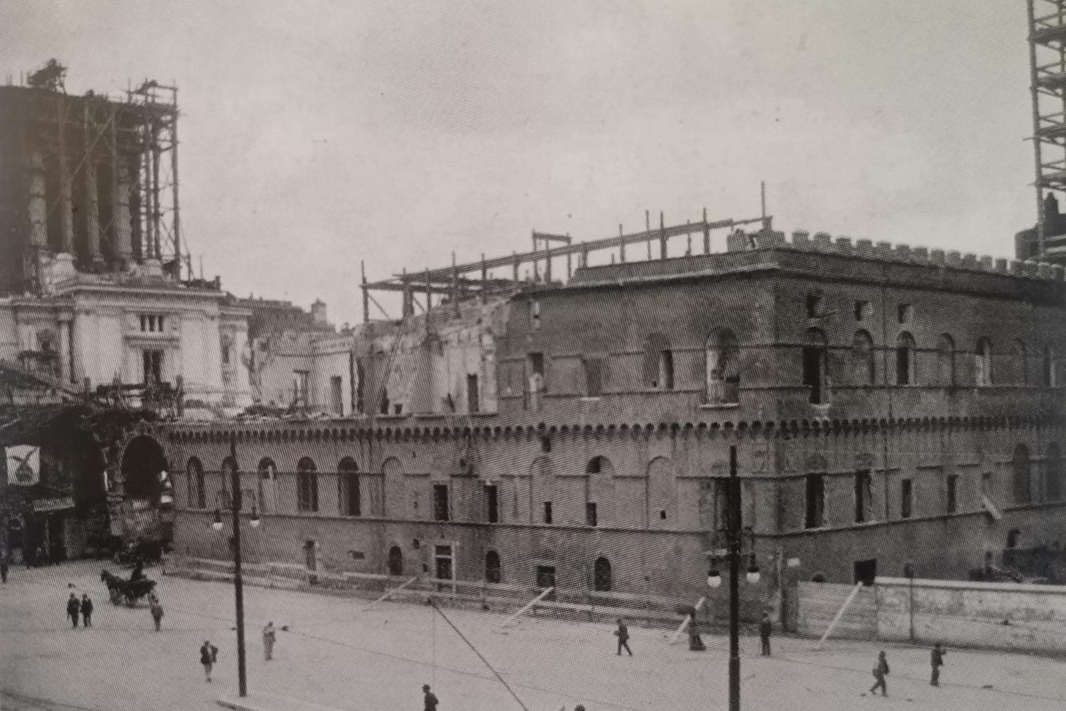 Il Palazzetto Venezia all’inizio delle demolizioni; sullo sfondo, il Vittoriano in costruzione, 1910 (da&nbsp;M. R. Coppola,&nbsp;La fabbrica del Vittoriano. Scavi e scoperte in Campidoglio (1885-1935), Roma 2012)