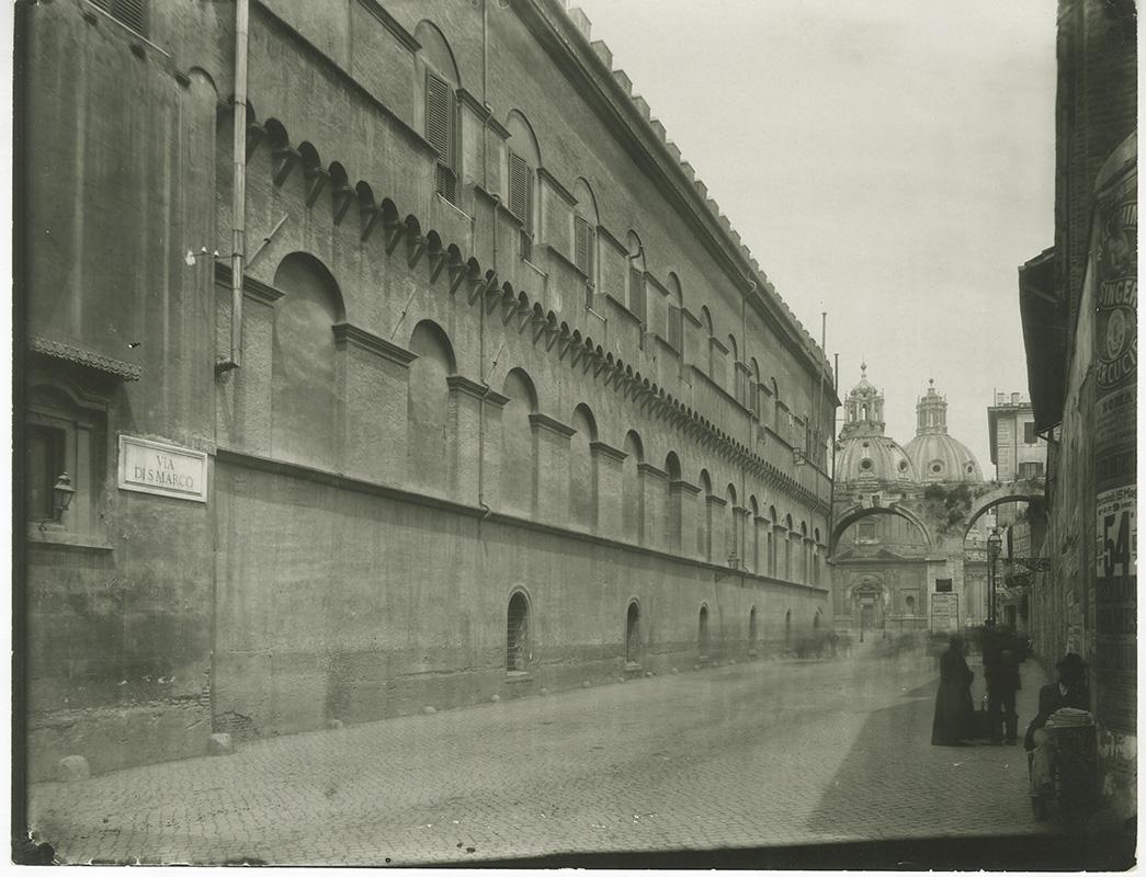 Façade of the Palazzetto facing Via di San Marco before it was moved; the churches of Santa Maria di Loreto (Mary of Loreto) and SS Nome di Maria (the Most Holy Name of Mary) can be seen in the background, late 1800s
