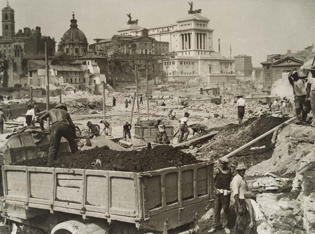 The Imperial Fora during demolition and construction. In the background, the eastern side of the Vittoriano (the Brasini Wing), also under construction, in a photograph taken 23 September 1932
