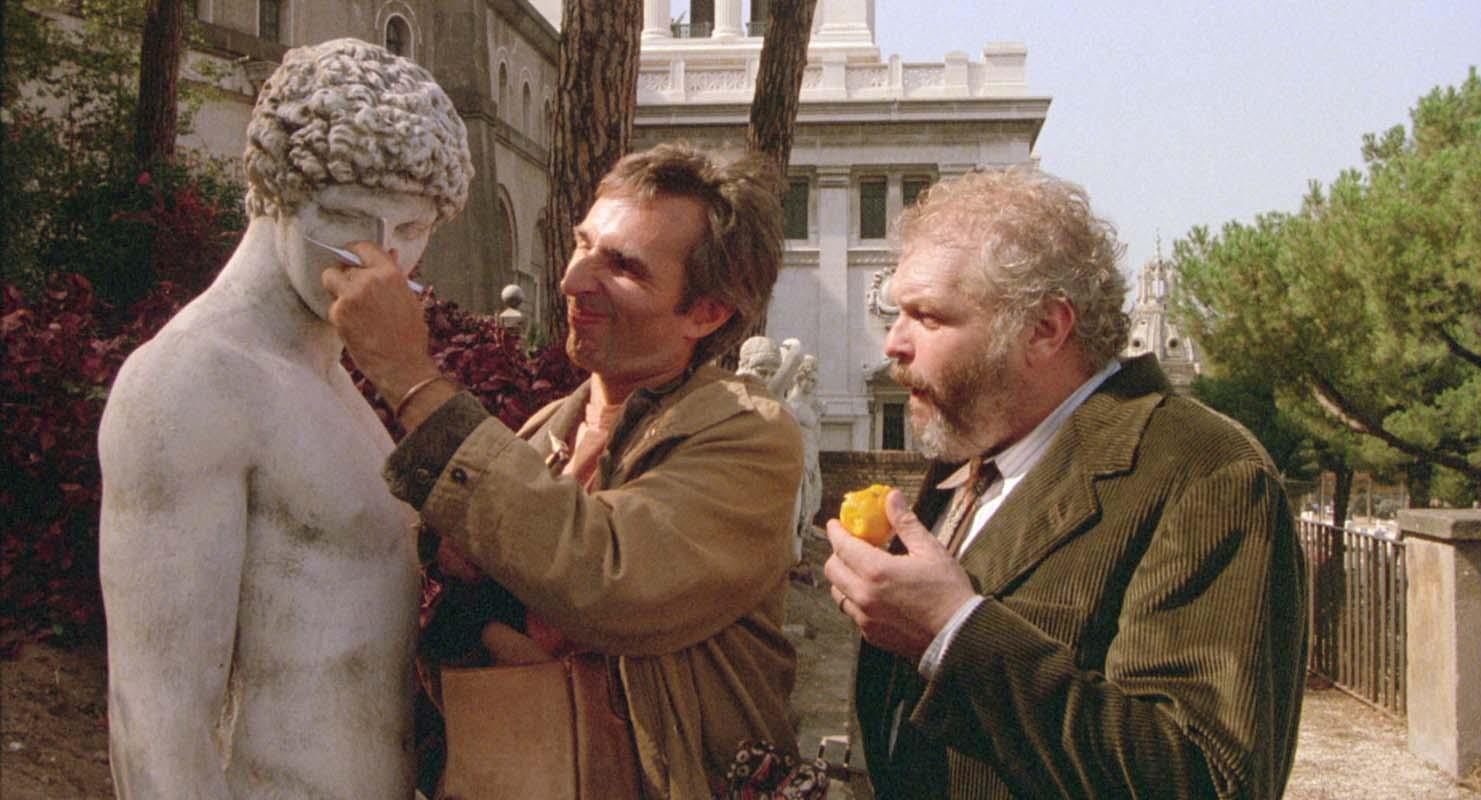 Scena dal film Il ventre dell’architetto (The Belly of an Architect) di Peter Greenaway del 1987: sullo sfondo il lato orientale del Vittoriano, detto Ala Fori Imperiali o Ala Brasini
