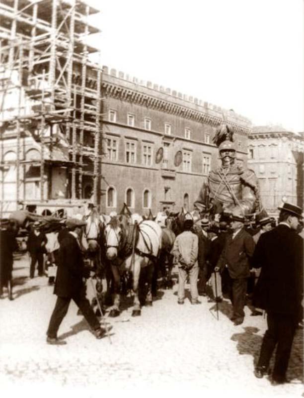 Il trasporto per le vie di Roma (sullo sfondo Palazzo Venezia) nel 1910 del gruppo equestre della statua di Vittorio Emanuele II diviso in più parti
